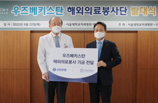 진옥동 신한은행장(우)이 구영 서울대치과병원장에게 우즈베키스탄 해외 의료봉사 기금을 전달하고 있다